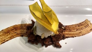 helado de plátano dominico servido sobre un bizcocho suave de semillas de cacao y con un trazo de mole poblano, acompañado de tapioca
